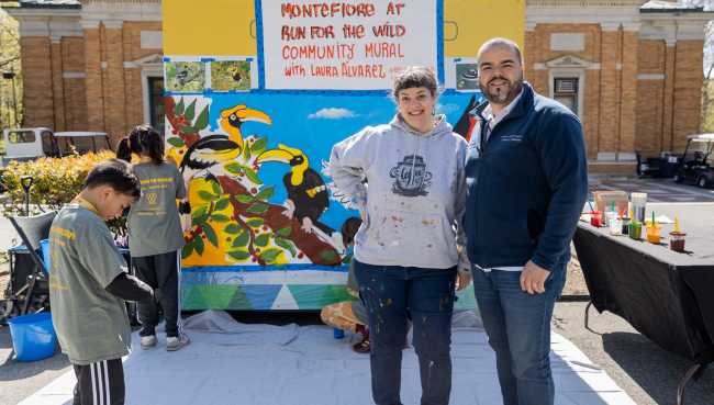 Local Artist Laura Alvarez and several helpers stand in front of the large scale mural they designed to celebrate the endangered Hornbill bird.