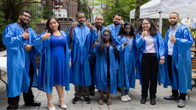 A group of Project SEARCH graduates in blue graduation robes pose for the camera.