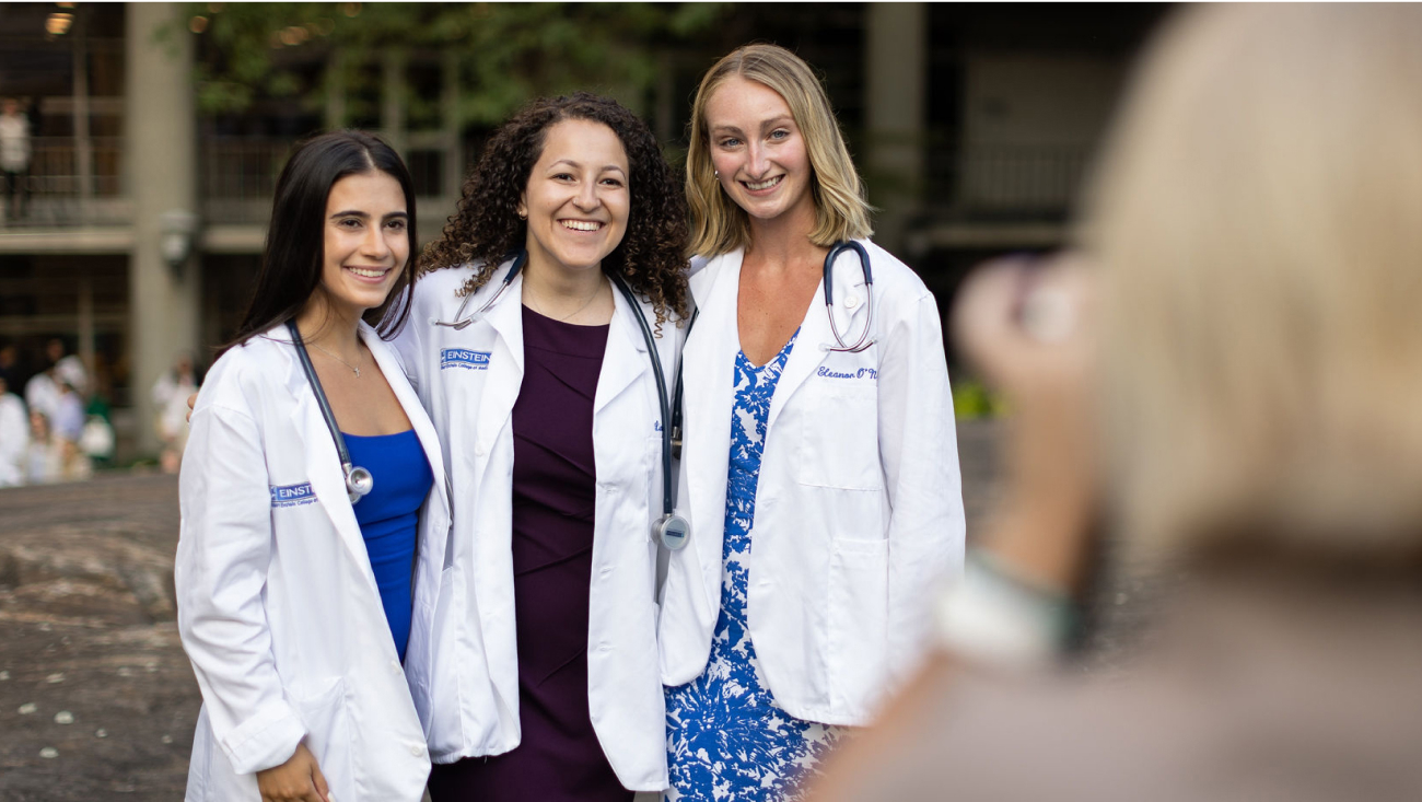 Three med students smile for a photographer.
