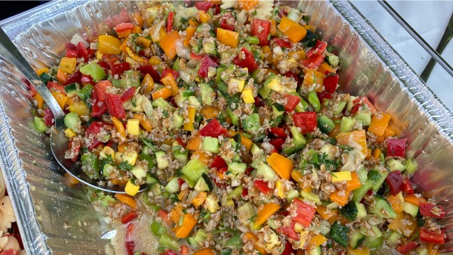 A prepared mix of fresh corn salad in a tinfoil tray. 