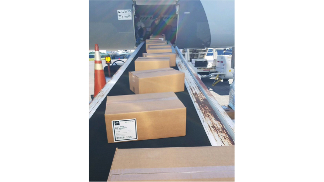 Boxes on the conveyor roll toward the cargo hold of the jet.