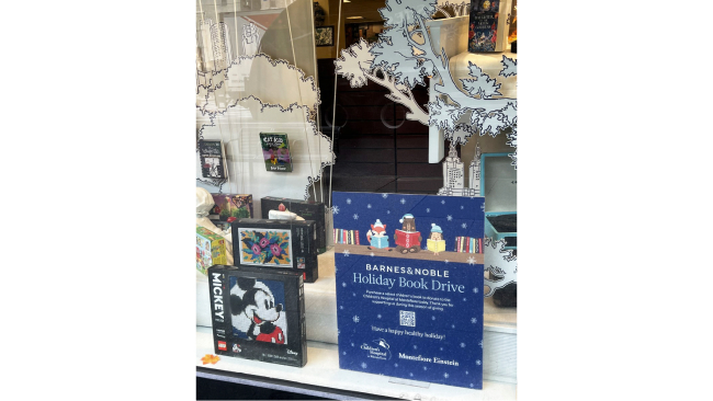 Holiday themed books are displayed in a shop window.