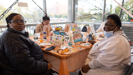 Two BOLD participants do a Halloween craft at a table. 