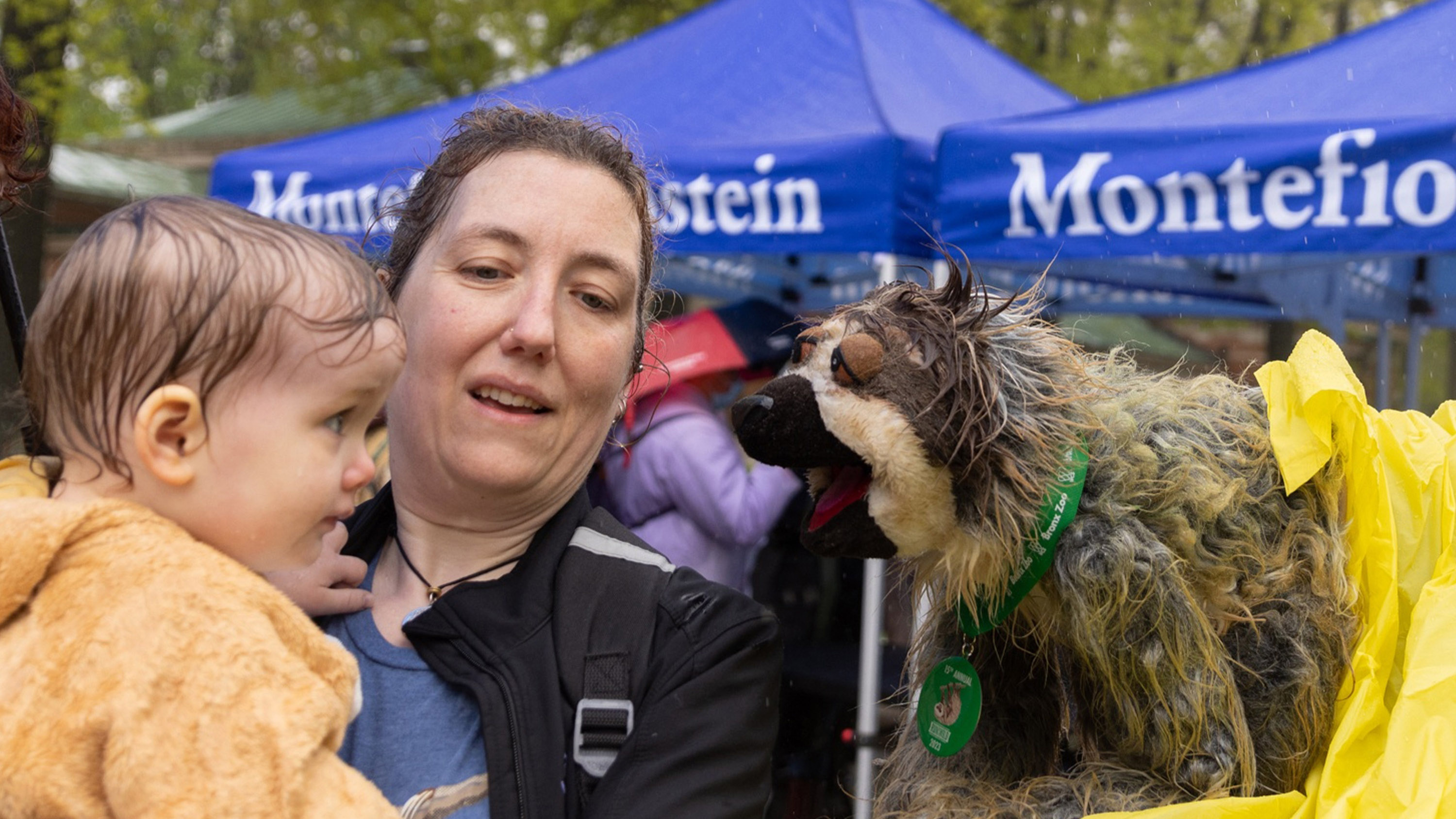 A baby delightedly meets a sloth puppet.