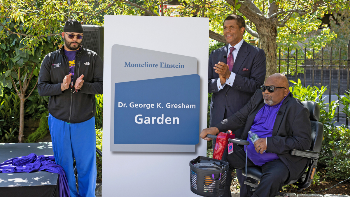Dr. Gresham and Dr. Ozuah stand next to the new sign for the Dr. George K. Gresham Garden.