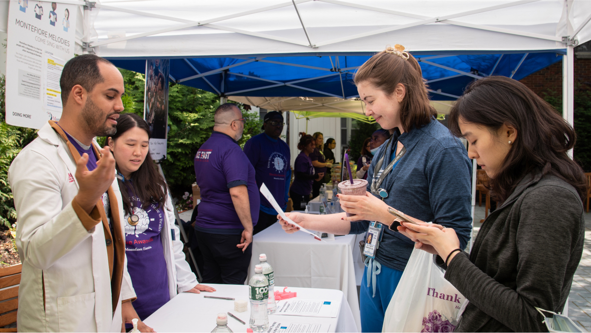 Participants and staffers discuss stroke awareness at an information table.