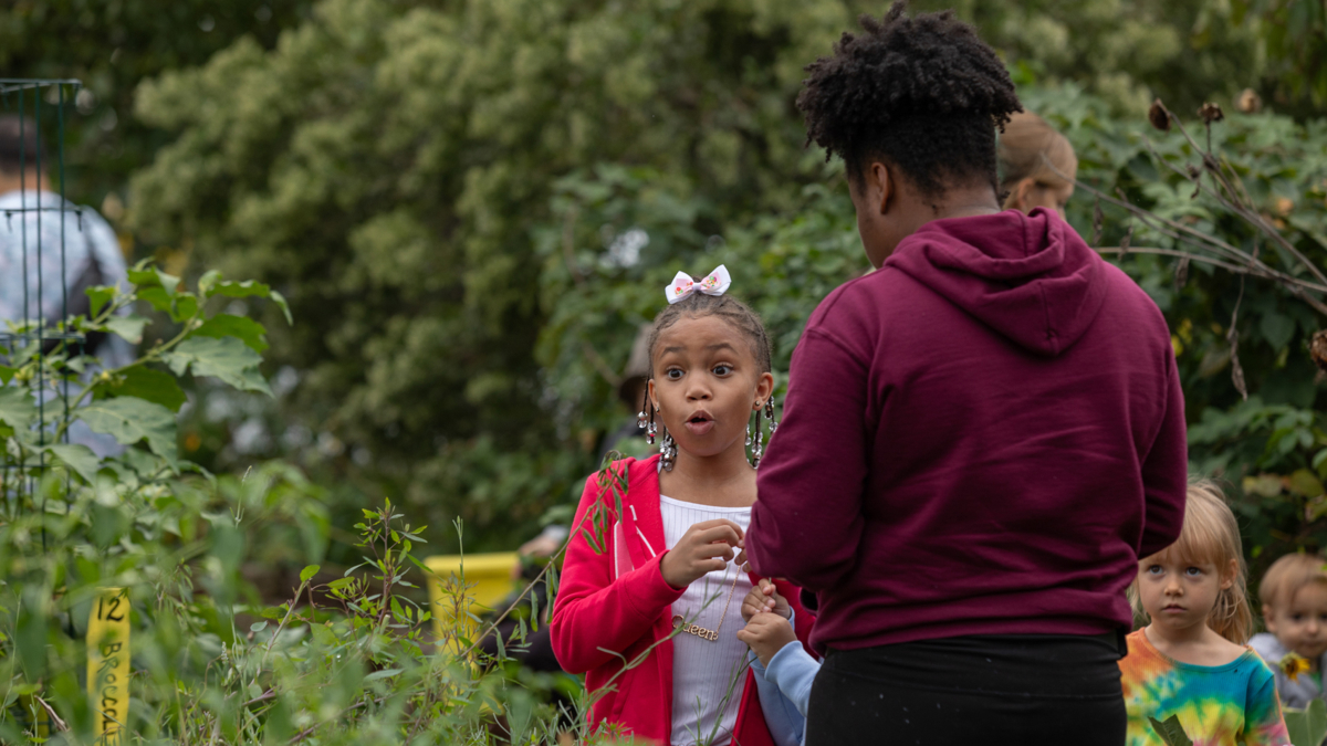 A child enjoys a trip to the New Roots community farm.