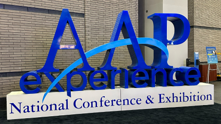 The 3D sculpture done in blues, reads "AAP experience National Conference & Exhibition"