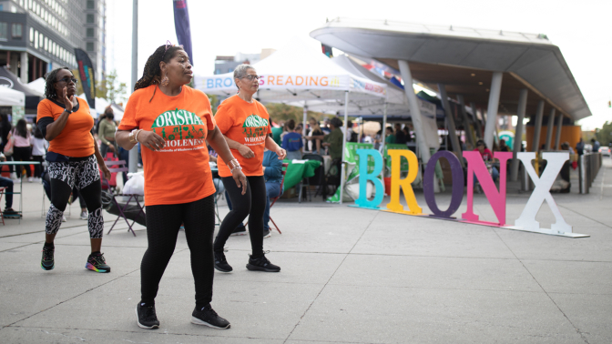 Participants walk by the large multicolored 'Bronx' sign.
