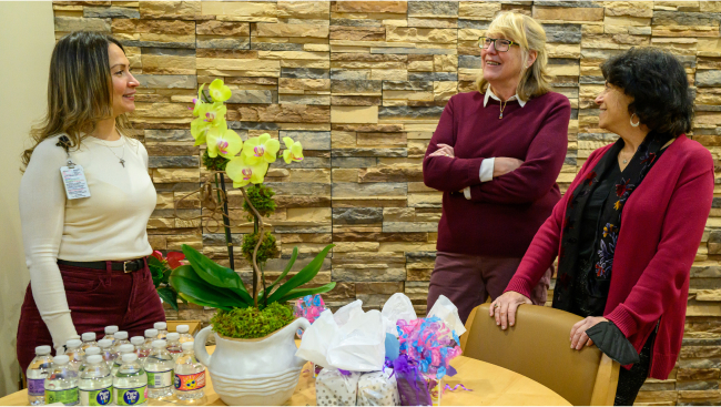 Three staff members talkign around a table.