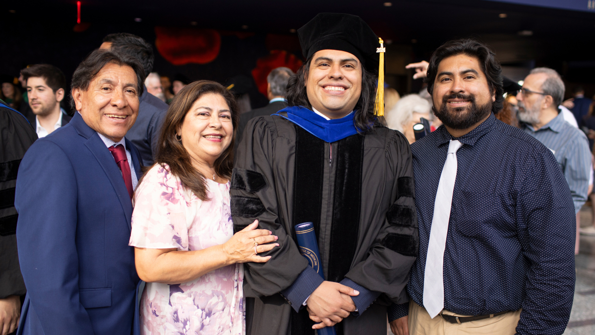 Proud family and friends pose with a graduate.