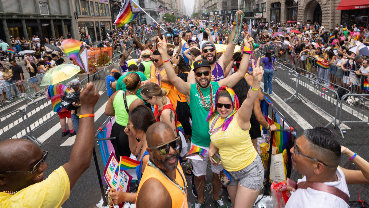 Float riders cheer and hold up their arms in celebration.