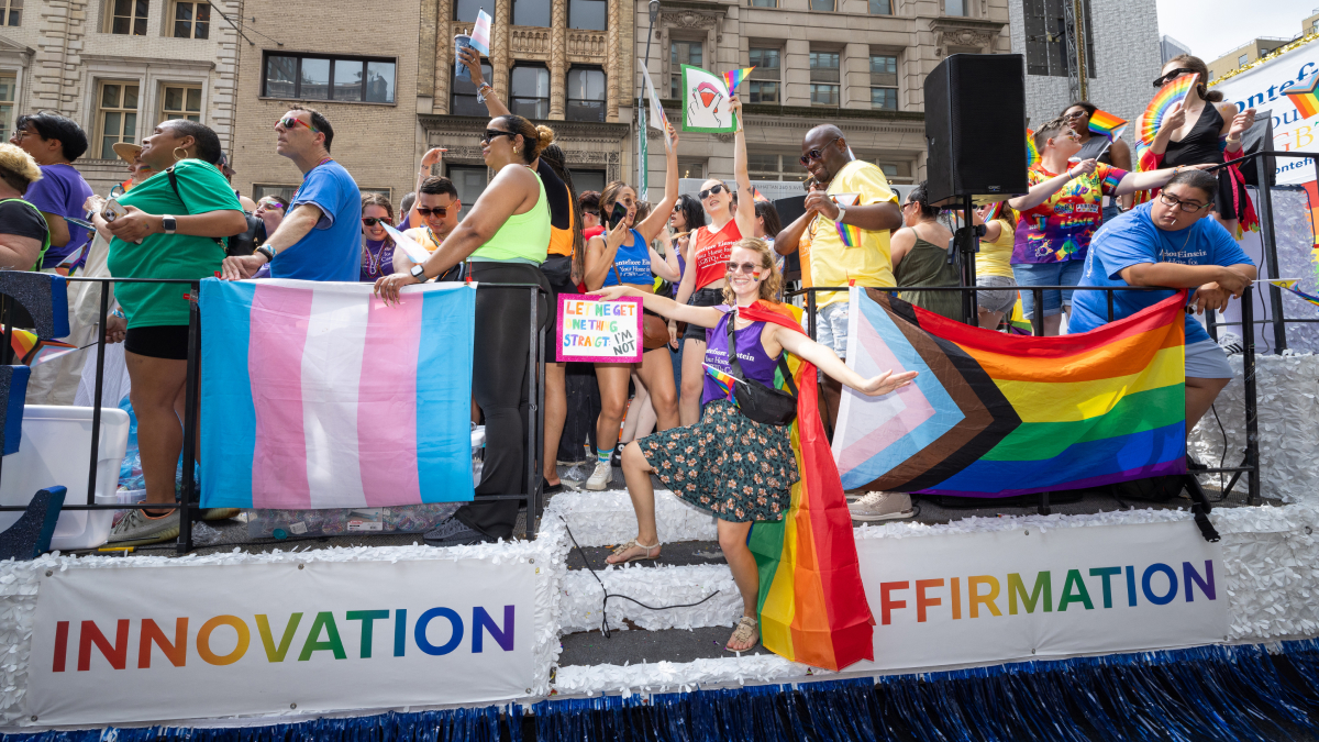 A side view of the Montefiore Einstein float, with the Transgender Pride flag and several rainbow flags.