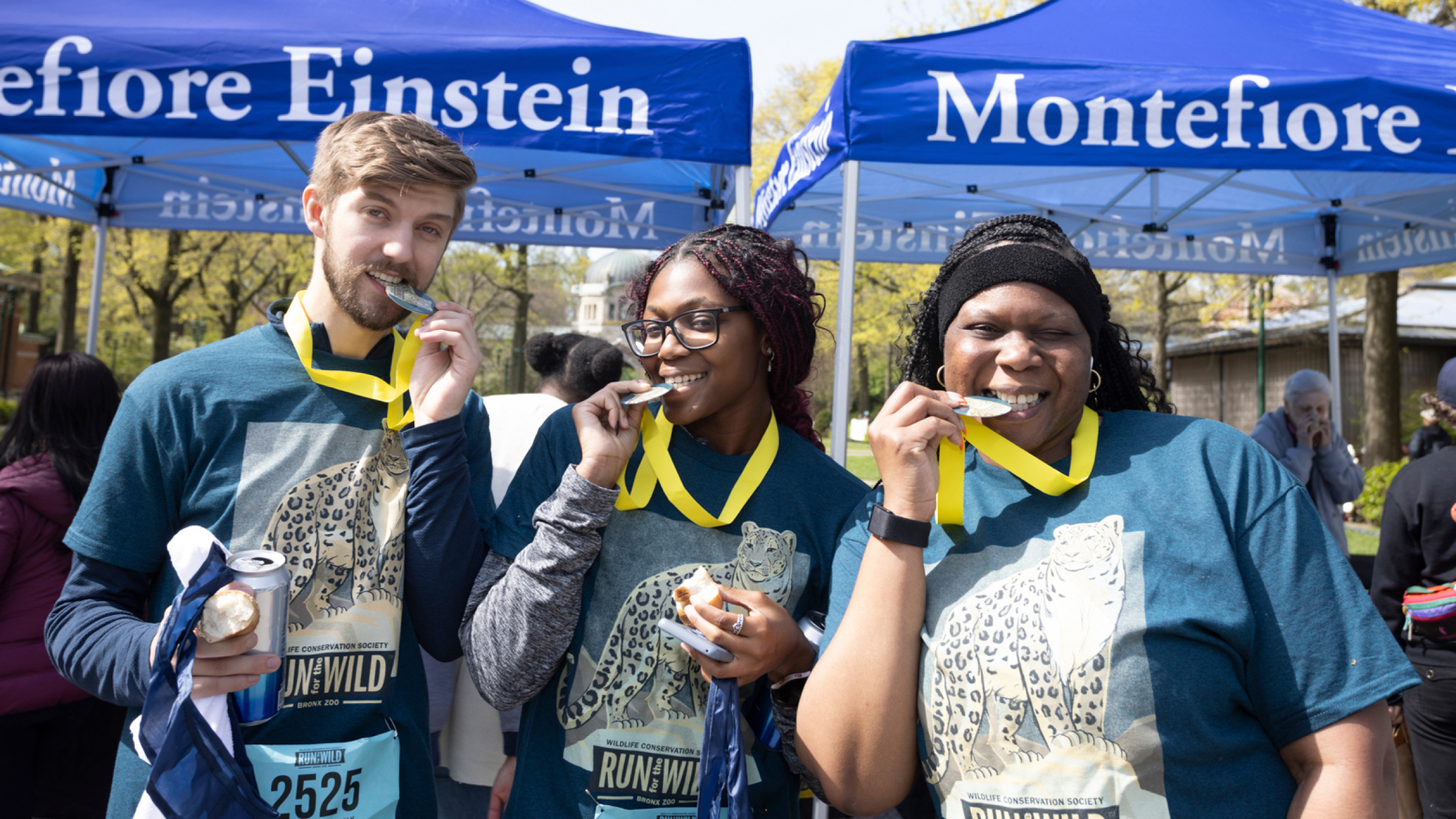 Three proud runners show their medals for completing the race.