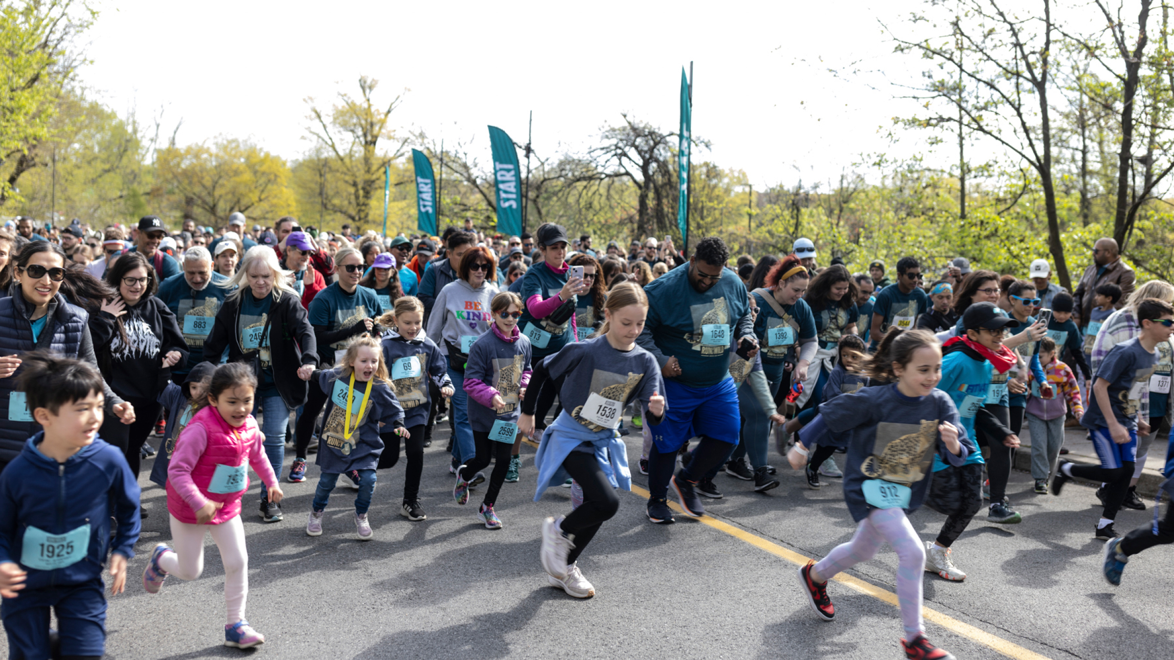 A crowd lines the way as runners pass by.