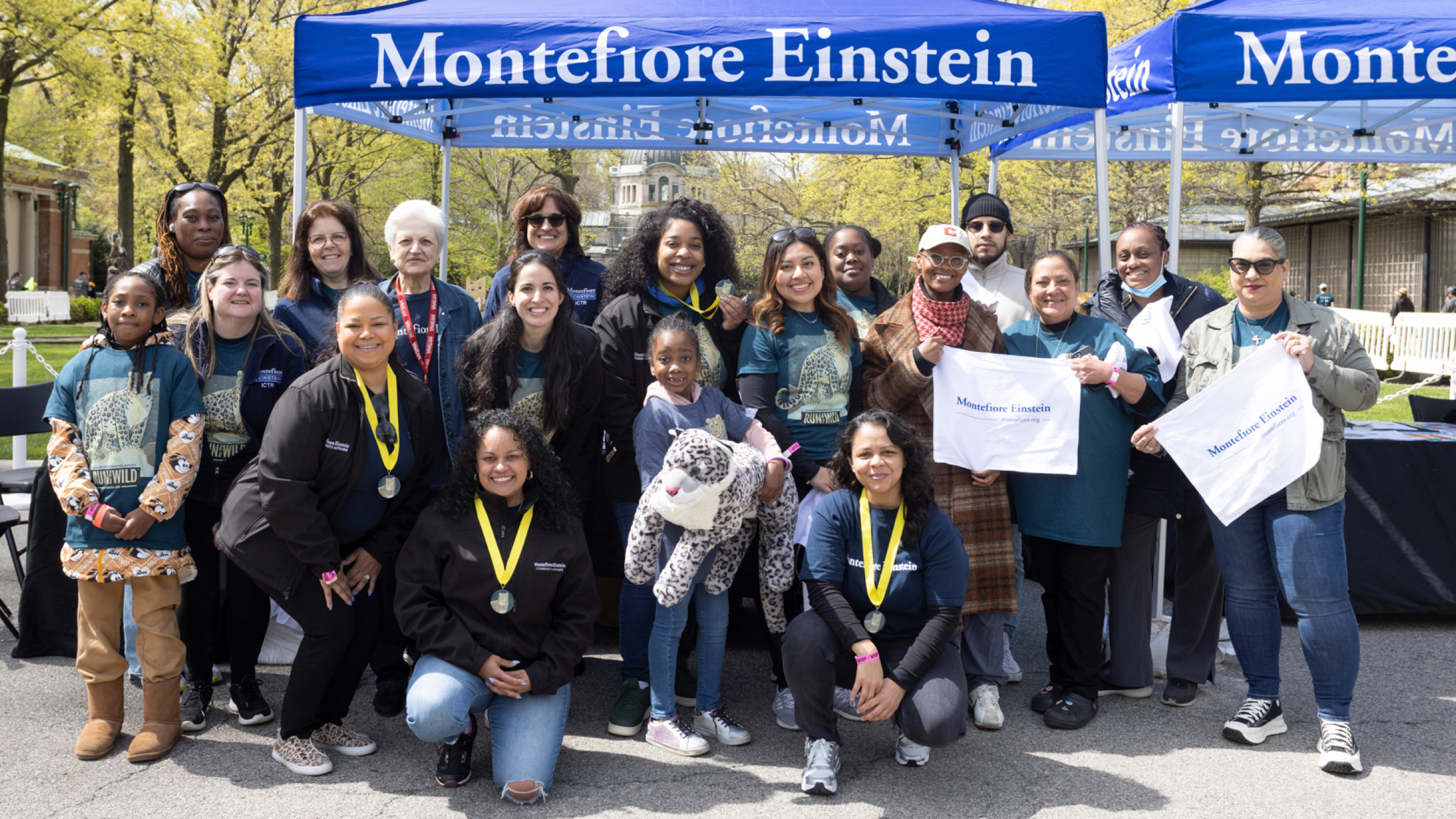 Runners and supporters pose under the Montefiore Einstein canopy for a group photo.