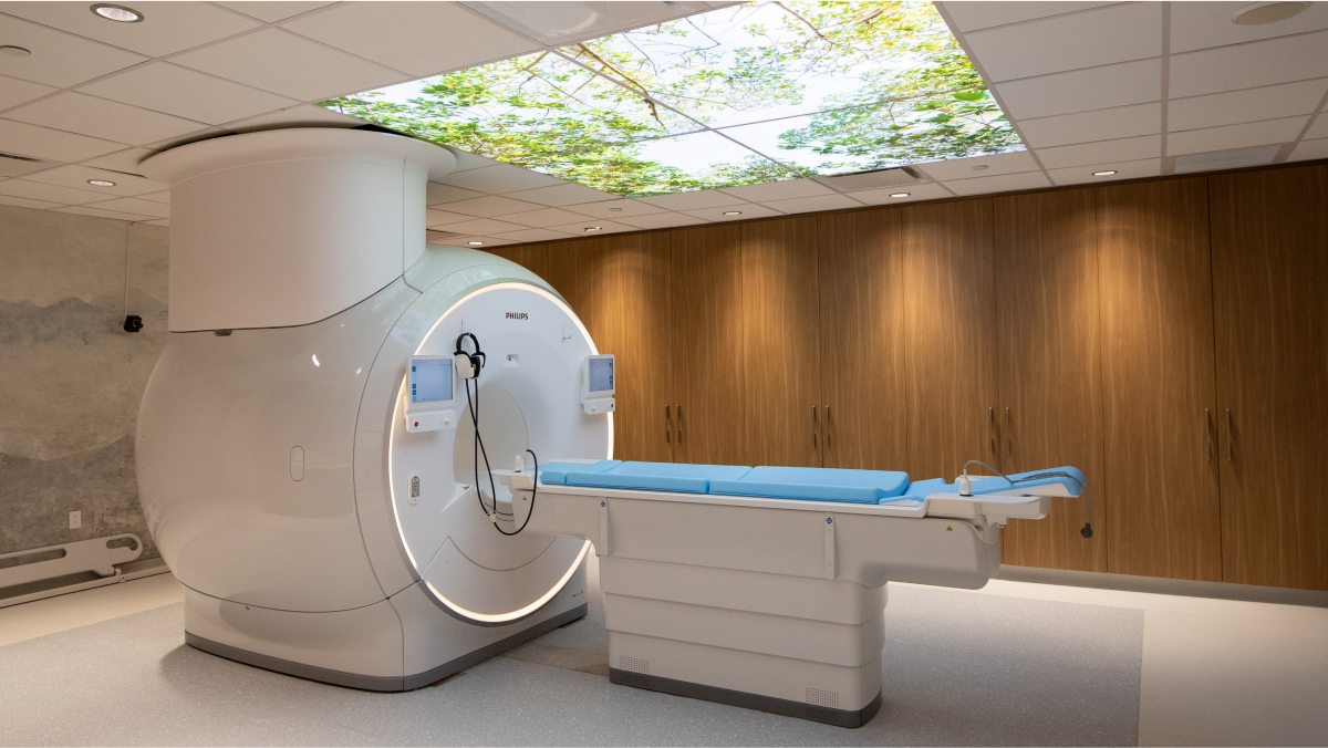 A scanning machine in a wood panelled room, featuring a forest scene overhead light display for soothing effect.