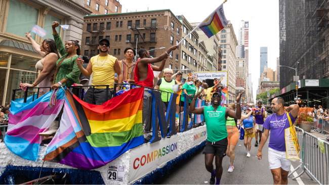 The Montefiore World Pride Day float, decorated with bright flags, carries happy parade goers down the route.