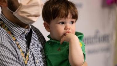 Father holding child with two fingers on his mouth