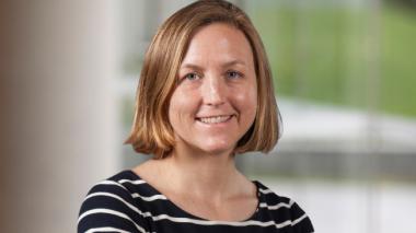 Kimberly J Reidy, MD, FAAP.  Smiling at the camera, she wears a navy blue shirt with white stripes. 