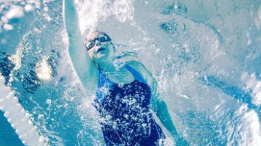 Woman swimming in blue bathing suit