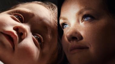 A baby's face and a woman's face shown with dramatic lighting.