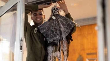 Man hanging skeleton on window