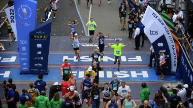 A sky view of two Champions for CHAM runners crossing the finish line of the Marathon, surrounded by crowds of onlookers.