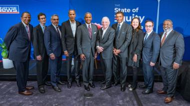 A row of people in formal business attire stand for a photo. (The U.S. News & World Report Panel on Healthcare Equity)