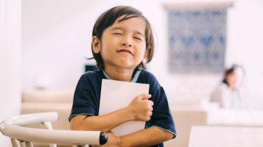 Happy child hugging a book.