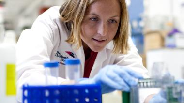 A researcher works on a lab bench running tests. 