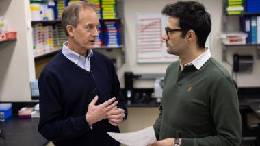 A senior advisor and younger student confer.