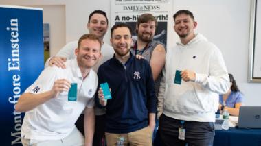Five proud Yankees staffers hold up green flu-vaccine cards.