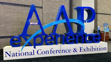The 3D sculpture done in blues, reads "AAP experience National Conference & Exhibition"