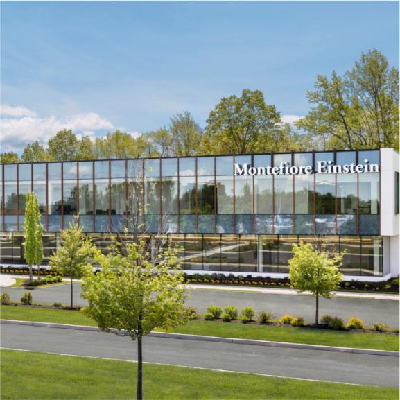 A view of a glass-fronted professional medical building; Montefiore Einstein Orthopedic Surgery, Montefiore Einstein Advanced Care, Montefiore Nyack and Burke Rehabilitation all offer services under one roof in the custom-designed, future-forward facility.