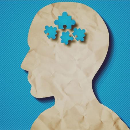 On a blue background, a cut out of a human profile. In the same blue, a set of jigsaw pieces are arranged in the center of the head.
